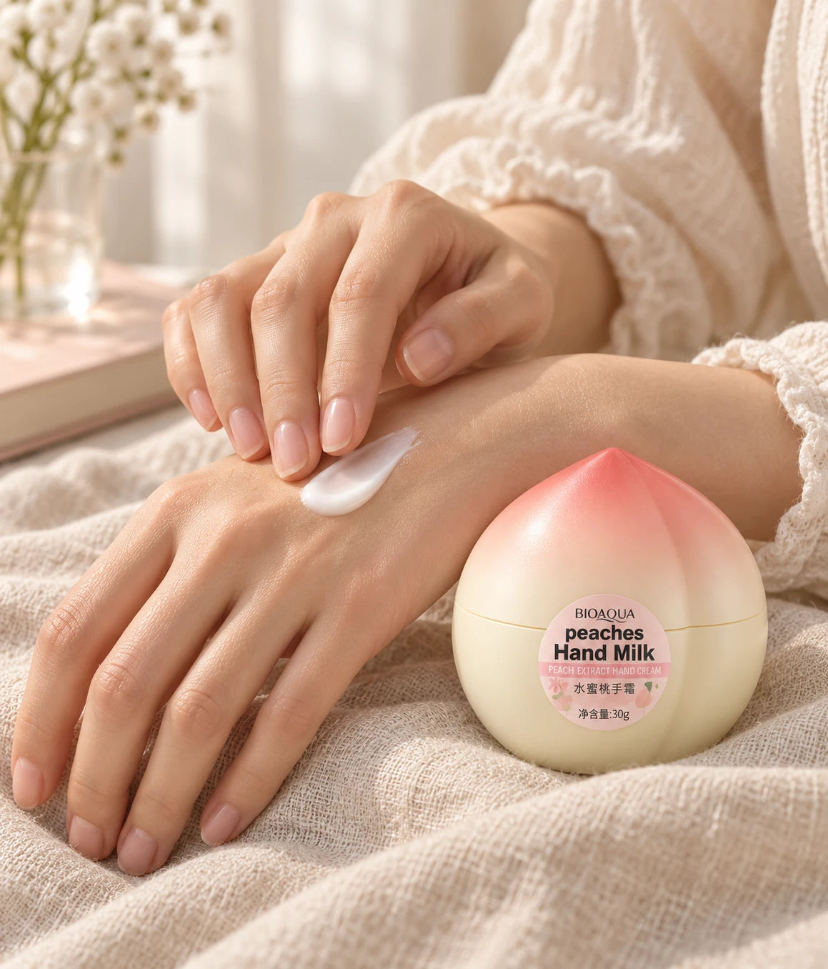 BIOAQUA peach hand cream beside hands applying cream